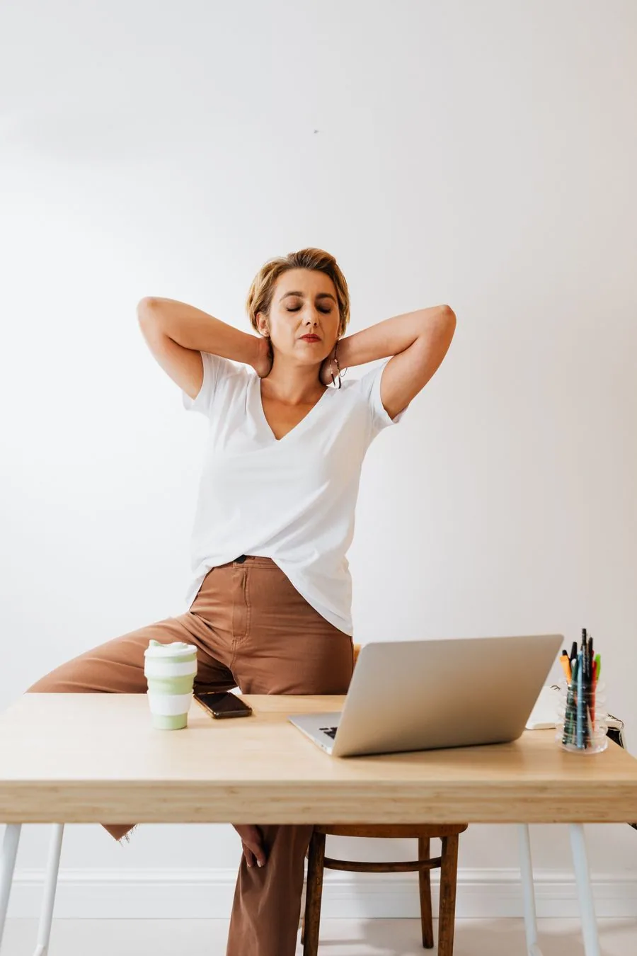 Colaboradora fazendo uma pausa de alongamento na própria mesa de trabalho